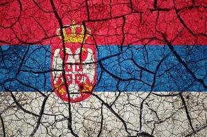 asciutto suolo modello su il bandiera di Serbia. nazione con siccità concetto. acqua problema. asciutto Cracked terra nazione. foto