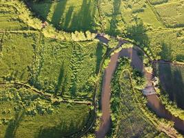 flussi meandro nel agricolo le zone durante il piovoso stagione con abbondanza di acqua. verde e caldo nel il mattina luce del sole. foto