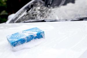 Questo uomo è lavaggio il auto e pulizia il macchina. foto