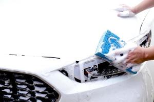 Questo uomo è lavaggio il auto e pulizia il macchina. foto