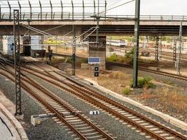 Visualizza su un' strada ponte passaggio al di sopra di il linee ferroviarie a un' nuvoloso giorno foto