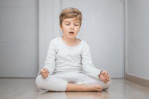 piccolo ragazzo Meditare con occhi Chiuso. foto