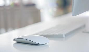 primo piano di un mouse e una tastiera su una scrivania foto
