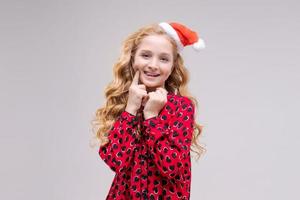 Natale ragazza. bellissimo adolescente modello nel Santa cappello isolato su sfondo foto