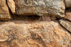 avvicinamento struttura foto di un' ruvido montagna rocce con crepe e ciottoli.