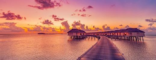 sorprendente tropicale tramonto panorama a Maldive isole. lusso ricorrere ville paesaggio marino con morbido guidato luci colorato sognare cielo. fantastico estate vacanza concetto, vacanza paesaggio Alba mare orizzonte