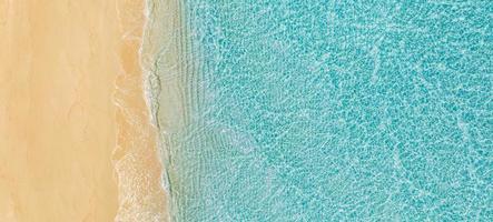 sabbioso riva del mare con turchese verde mare acqua. piccolo onde su il spiaggia. bellissimo Paradiso tropicale isola spiaggia sfondo, superiore aereo paesaggio turchese oceano su soleggiato giorno. la libertà estate viaggio foto