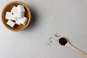zucchero cubi nel un' di legno piatto e cucchiaio con tè fedi su il cucina tavolo. fabbricazione Tè, tè rompere. superiore Visualizza foto
