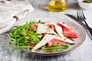 fresco insalata di anguria, feta formaggio, rucola e zucca semi su un' piatto. biologico dieta. foto