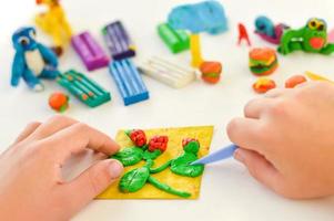 un' avvicinamento di mani con plastilina, figli di mestieri e un applicazione su il tema di raccolto. foto