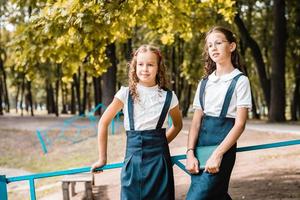 Due allievi nel scuola uniforme godere un' camminare nel il parco su un' caldo giorno foto