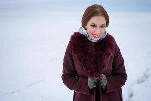 bellissimo donna nel un' caldo cappotto su un' inverno sfondo. foto