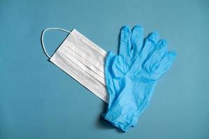 chirurgico bianca maschera e latice guanti per protezione su un' blu sfondo foto