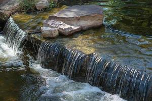 un' piccolo cascata nel un' grande ornamentale stagno foto