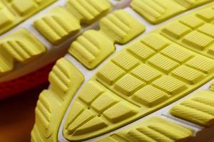 avvicinamento di il Filo di un' giallo scarpe da ginnastica, il strutturato modello di il suola. foto