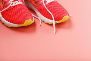 gli sport rosa scarpe da ginnastica su un' rosa sfondo con gratuito spazio. foto