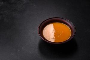 delizioso caldo zucca e carota la minestra puré con spezie e erbe aromatiche foto