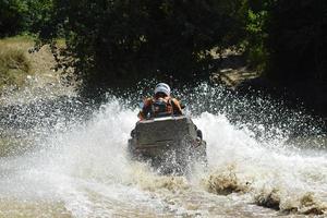 il uomo su il atv croci un' ruscello foto