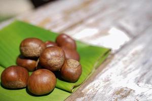 fresco castagne isolato su un' di legno pavimento, castagne avere un oleoso dolce gusto. foto