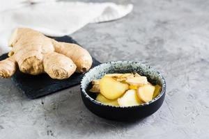 affettato fresco crudo Zenzero radice nel un' ciotola su il tavolo. alternativa medicina foto