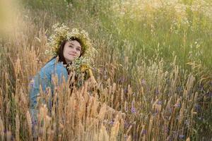 bella ragazza che cammina sul campo in estate con fiori di campo. foto