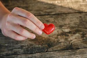 poco rosso cuore bugie nel il palme su un' di legno sfondo, il concetto di amore e romanza. foto