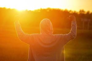 un' uomo nel il leggero di il tramonto con il suo mani su, il concetto di successo, la libertà e gioia foto