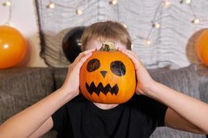 adolescente con trucco su il suo viso e con un' zucca nel il suo mani per Halloween. foto