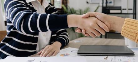 attività commerciale persone stretta di mano a incontro tavolo nel ufficio insieme. giovane uomo d'affari e donna d'affari lavoratori esprimere accordo di investimento affare foto