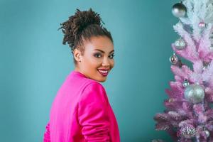 allegro afro americano donna su il Natale albero sfondo. Natale, nuovo anno, felicità, vacanze concetto foto