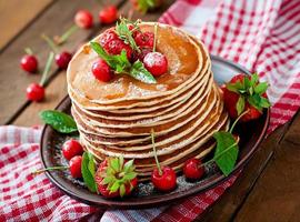 frittelle con frutti di bosco e sciroppo in stile rustico foto