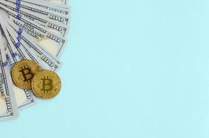 d'oro bitcoin e centinaio dollaro fatture bugie su leggero blu sfondo