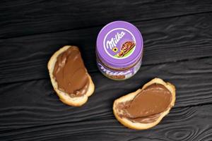 Kharkov, Ucraina - luglio 2, 2021 può di milka zuccherato nocciola cacao diffusione con classico lilla colore design su nero tavolo foto