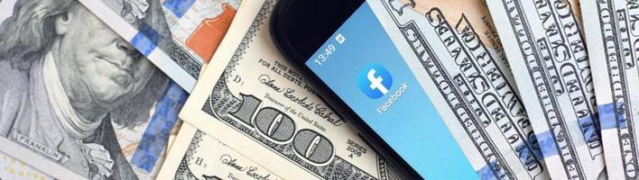 Kharkiv, Ucraina - Maggio 4, 2020 smartphone schermo con Facebook App e lotto di centinaio dollaro fatture. attività commerciale e sociale networking concetto foto