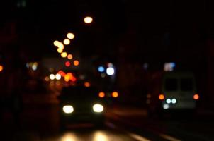 sfocato notte scena di traffico su il carreggiata. sfocato Immagine di macchine in viaggio con luminoso fari. bokeh arte foto