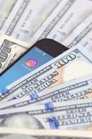 Kharkov, Ucraina - luglio 2, 2021 smartphone schermo con instagram App e lotto di centinaio dollaro fatture. attività commerciale e sociale networking concetto foto