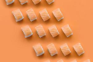 Filadelfia rotoli con salmone su arancia sfondo. minimalismo superiore Visualizza piatto posare modello con giapponese cibo foto