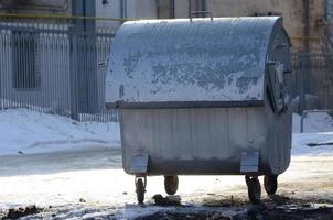 un' argento spazzatura contenitore sta vicino Residenziale edifici nel inverno foto