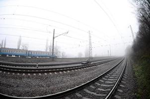 il ucraino suburbano treno si precipita lungo il ferrovia nel un' nebbioso mattina. fisheye foto con è aumentato distorsione