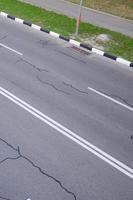 danneggiato cattivo asfalto strada con buche. toppa riparazione di asfalto foto