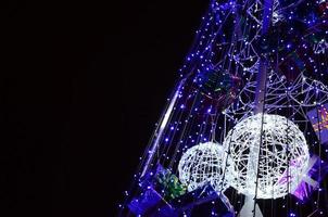 frammento di il nuovo anno albero. un' lotto di il giro luci di blu colore siamo collocato su un' conico telaio foto