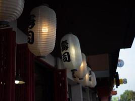 giapponese lanterna sospeso nel davanti di giapponese ristorante, giapponese testo su lanterna è Sushi giapponese cibo. foto