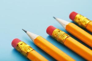 arancia matite con un gomma per cancellare su un' blu sfondo. foto