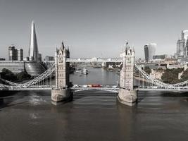 bellissimo nero e bianca foto di Londra Torre ponte con un iconico rosso autobus guida su esso.