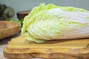 fresco Cinese cavolo bugie su un' di legno taglio tavola. ingrediente per cucinando foto