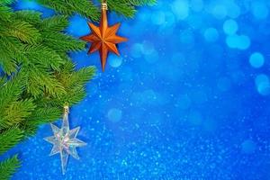 pino rami con arancia stella e ghiacciato su blu sfondo con bokeh. Natale, nuovo anno. copia spazio foto