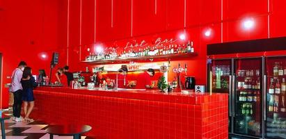 Phuket, Tailandia - marzo 2, 2022 rosso bar o bar con molti alcool potabile su mensola e coppia acquisto caffè o birra. bellissimo interno design e colorato con leggero concetto. foto