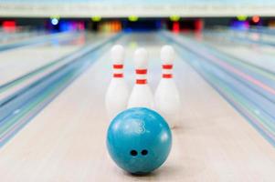 bowling gioco. avvicinamento di blu bowling palla dire bugie contro perni soggiorno su bowling vicolo foto