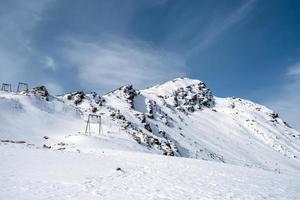 montagna gamma, ripido versante e snow-capped roccioso picchi con supporti per cavo auto foto