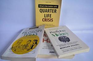 blitar, Indonesia - ottobre 9 ° 2022 selettivo messa a fuoco di parecchi libri intitolato trimestre vita crisi, tera filosofia e psicologia di i soldi isolato su bianca sfondo foto